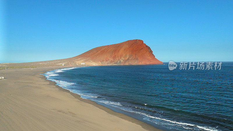 Aerial view of La Tejita Beach and volcanic cone of Montaña Roja, Tenerife, Canary Islands. Drone shot